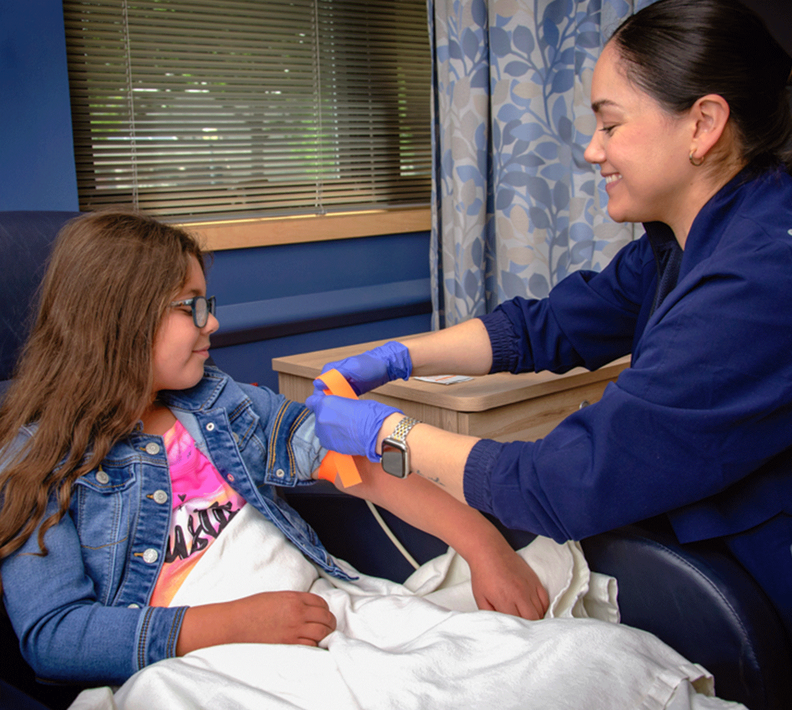 Female CCMH nurse prepping young girl for infusion service